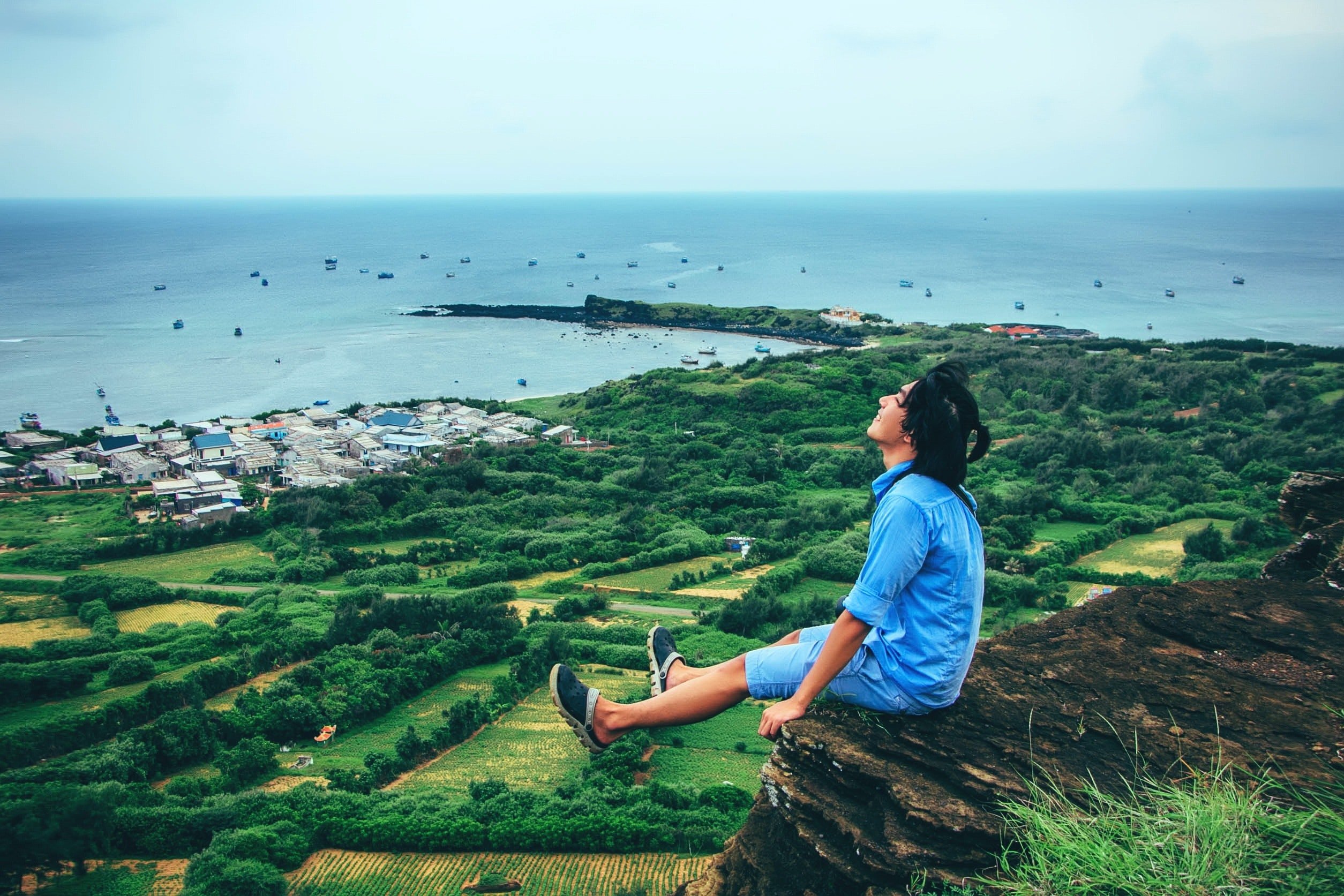 young-man-sitting-on-cliff-enjoying-freedom-in-nature